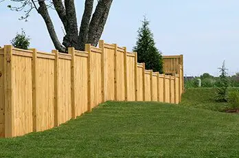 A wooden fence with grass in the foreground.