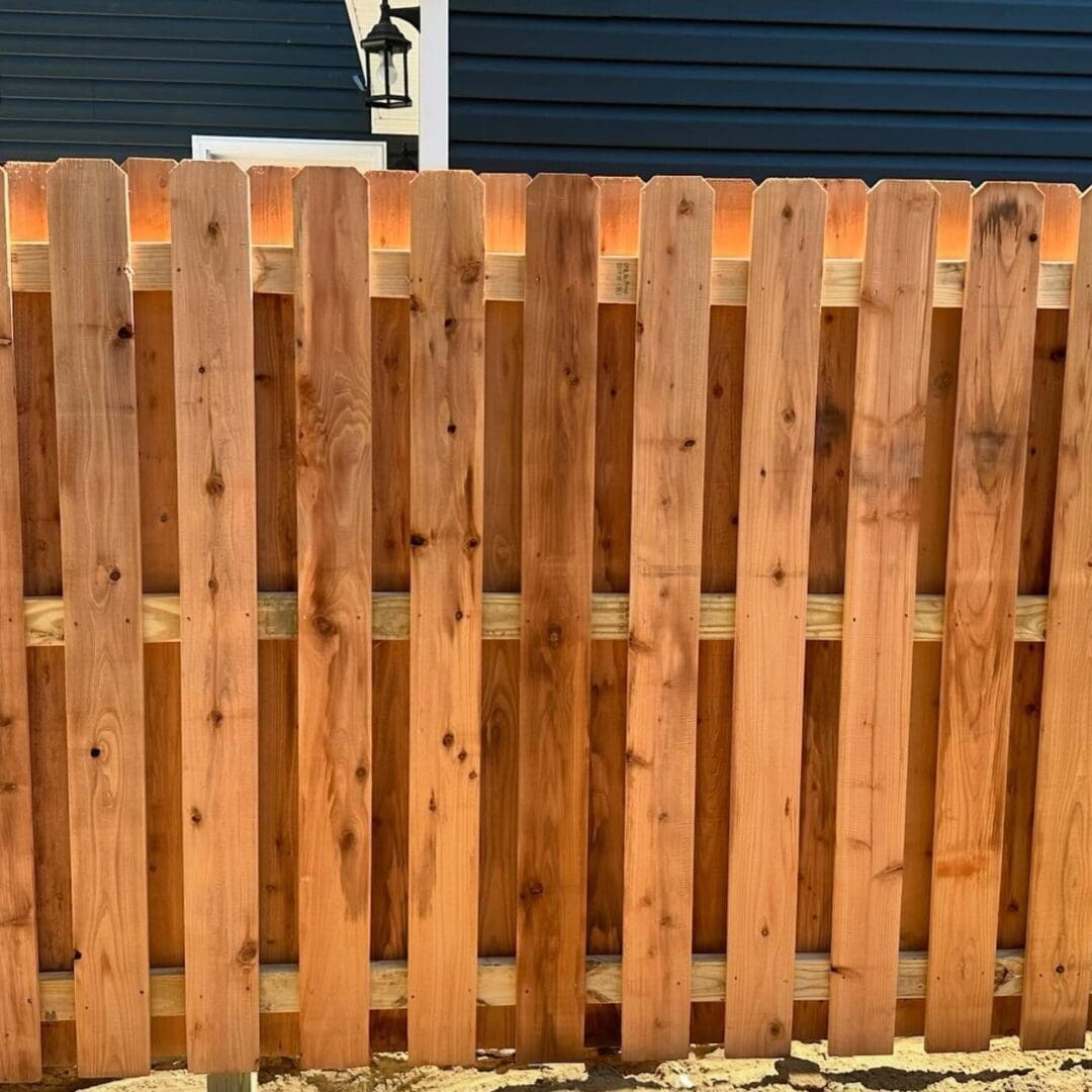 Wooden fence with house in background.